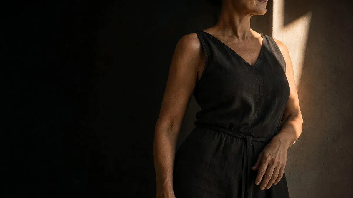 Soft directional light falling across a woman standing in a quiet room