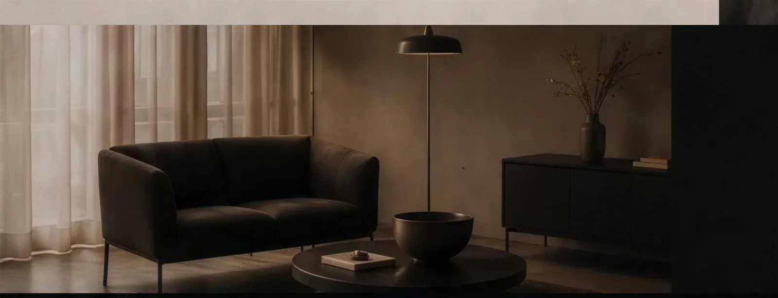 A quiet consultation room in Launceston with sheer curtains, dark seating and warm natural light