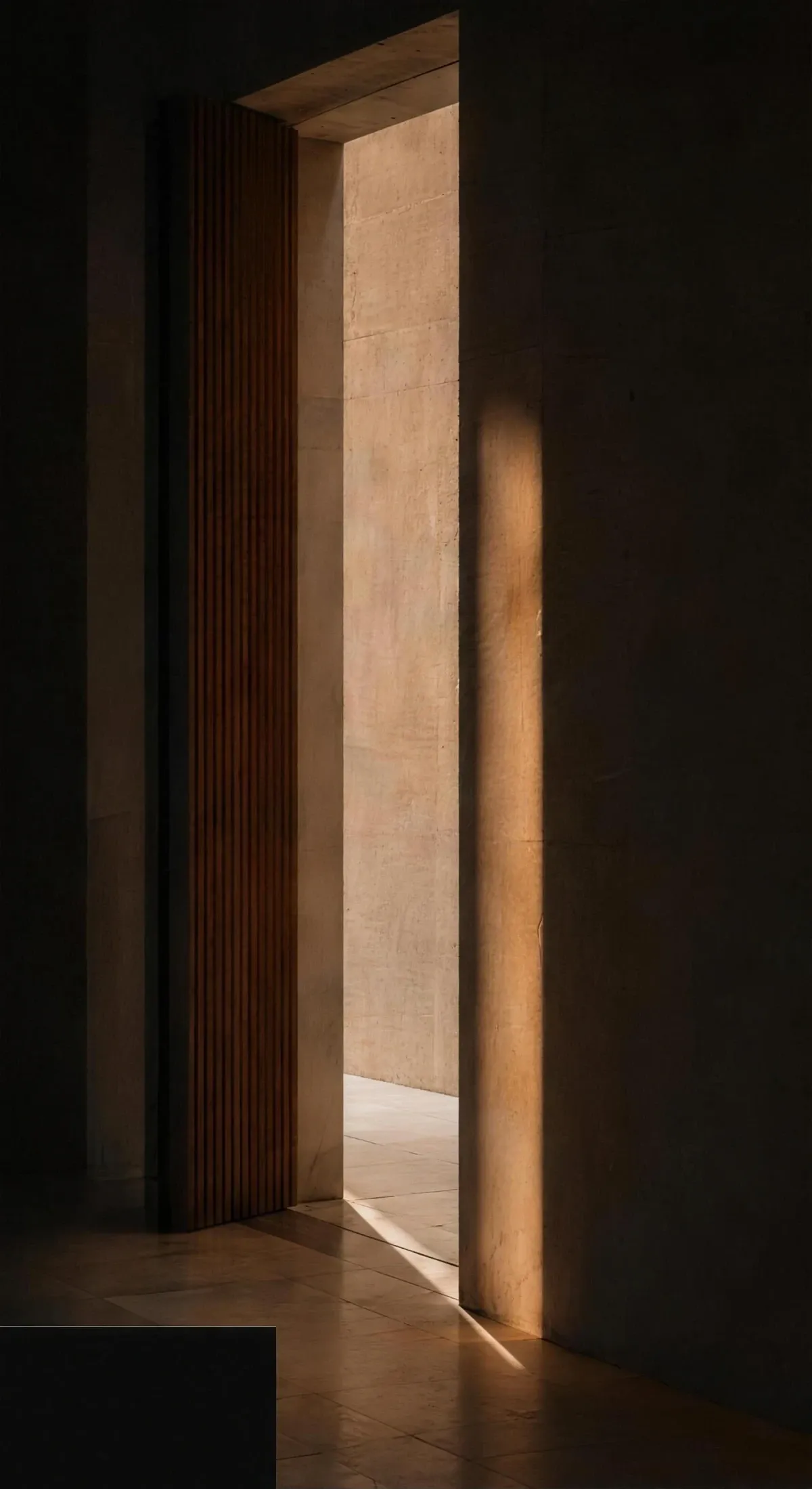 A narrow doorway opening onto warm late-afternoon light across stone and timber